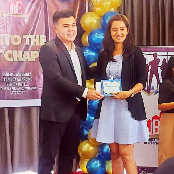 "SD Malou Santiago accepting an award during the JBC Annual Awards 2022 ceremony, dressed elegantly."